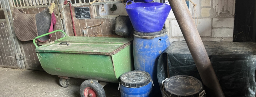 Chaotische Futterkammer mit Futtersäcken, Schüsseln und Messbechern – automatische PowerFeeder sorgen für sichere, stressfreie und staubfreie Pferdefütterung im Stall